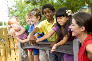 A group of diverse preschool students on a playground for an article titled, "	expelling black preschoolers can be a pipeline straight to prison" for successful black parenting magazine.