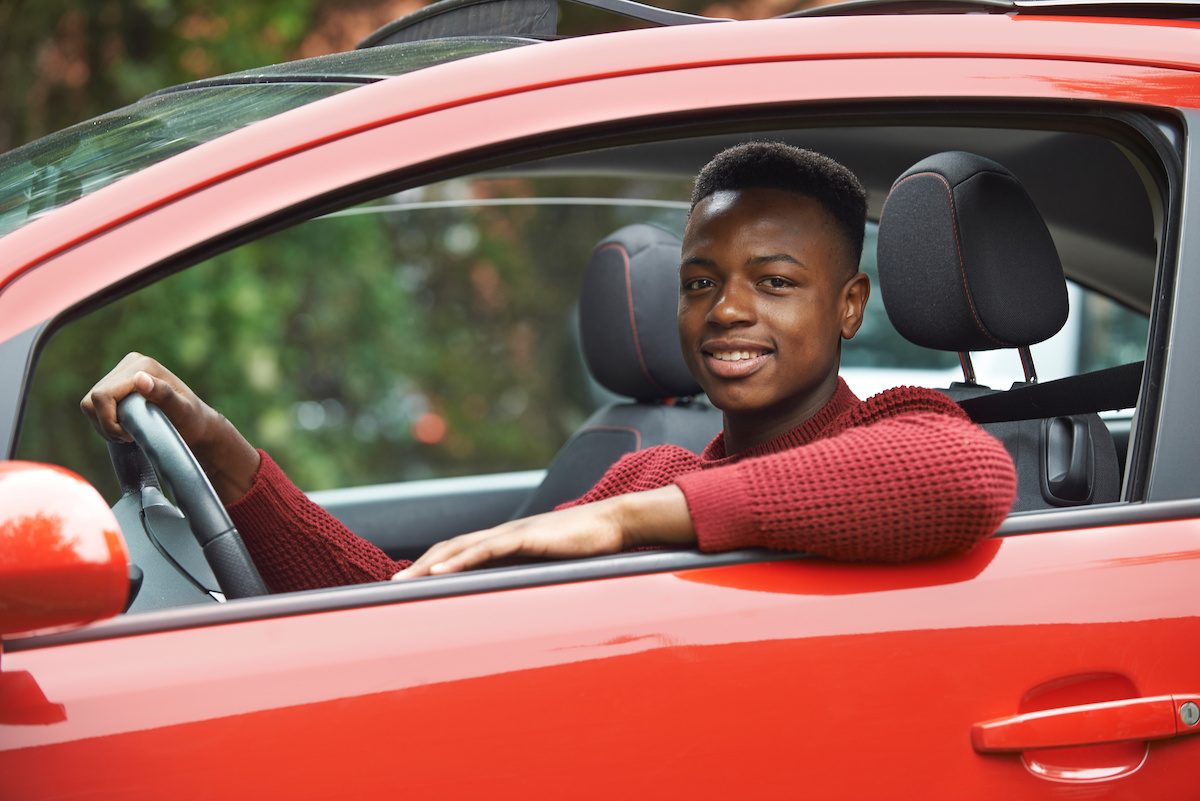 Male teenage driver looking out of car window