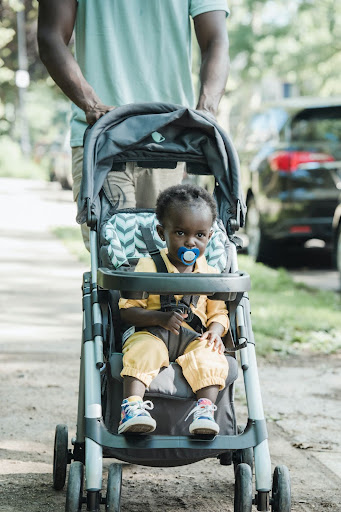 African american toddler girl sitting contentedly in a stroller.