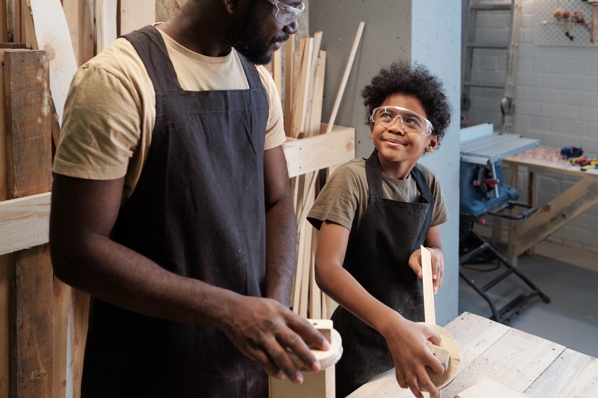 An african father and son work together in wood shop to increasing productivity