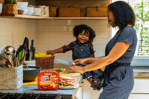 African-american mom with child in a more child friendly kitchen.