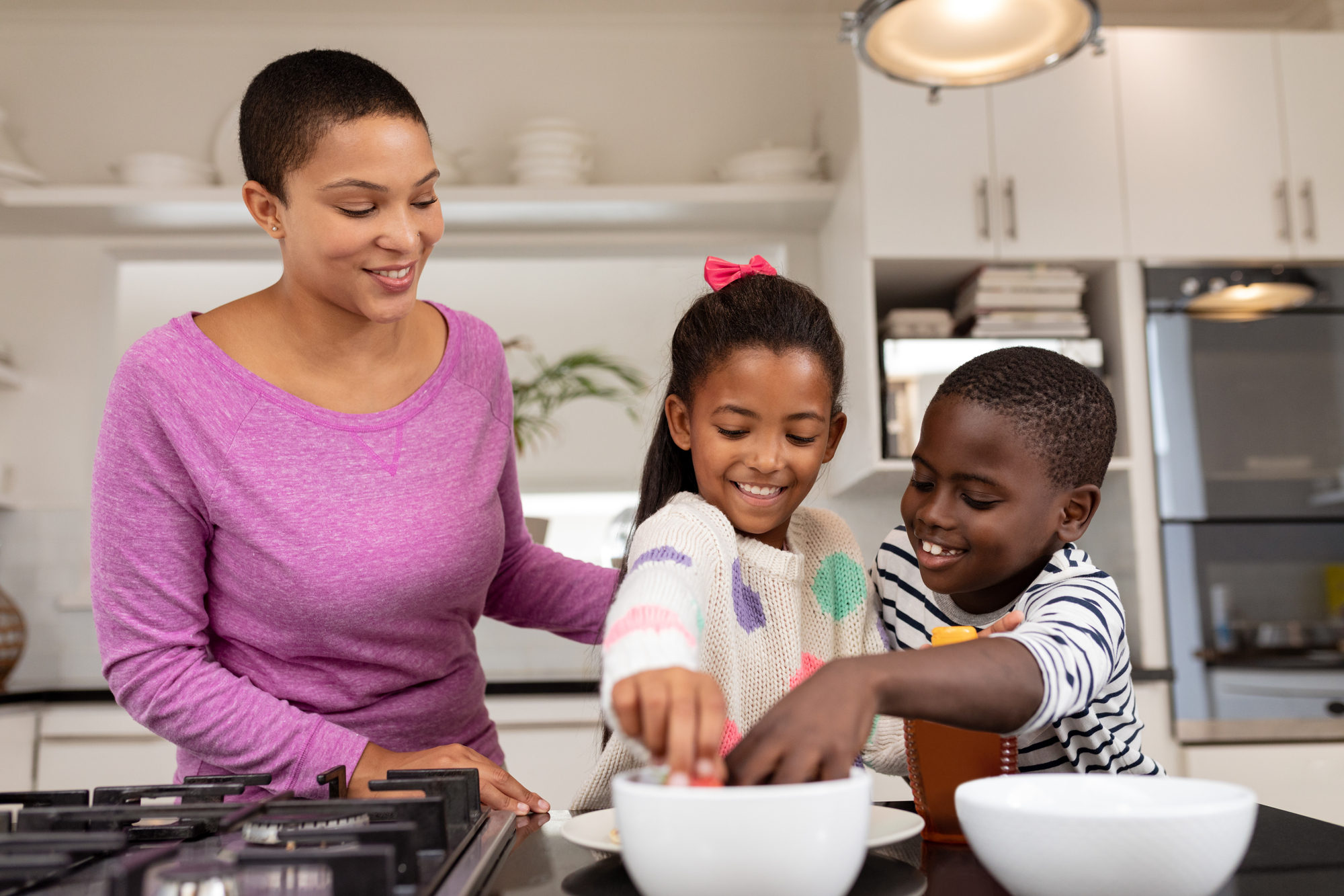 African american kids using mushroom soup to cook in the kitchen with their mom