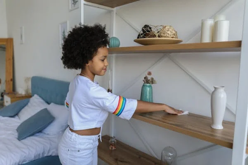 African american girl shows creative ways to keep your home organized with kids while cleaning