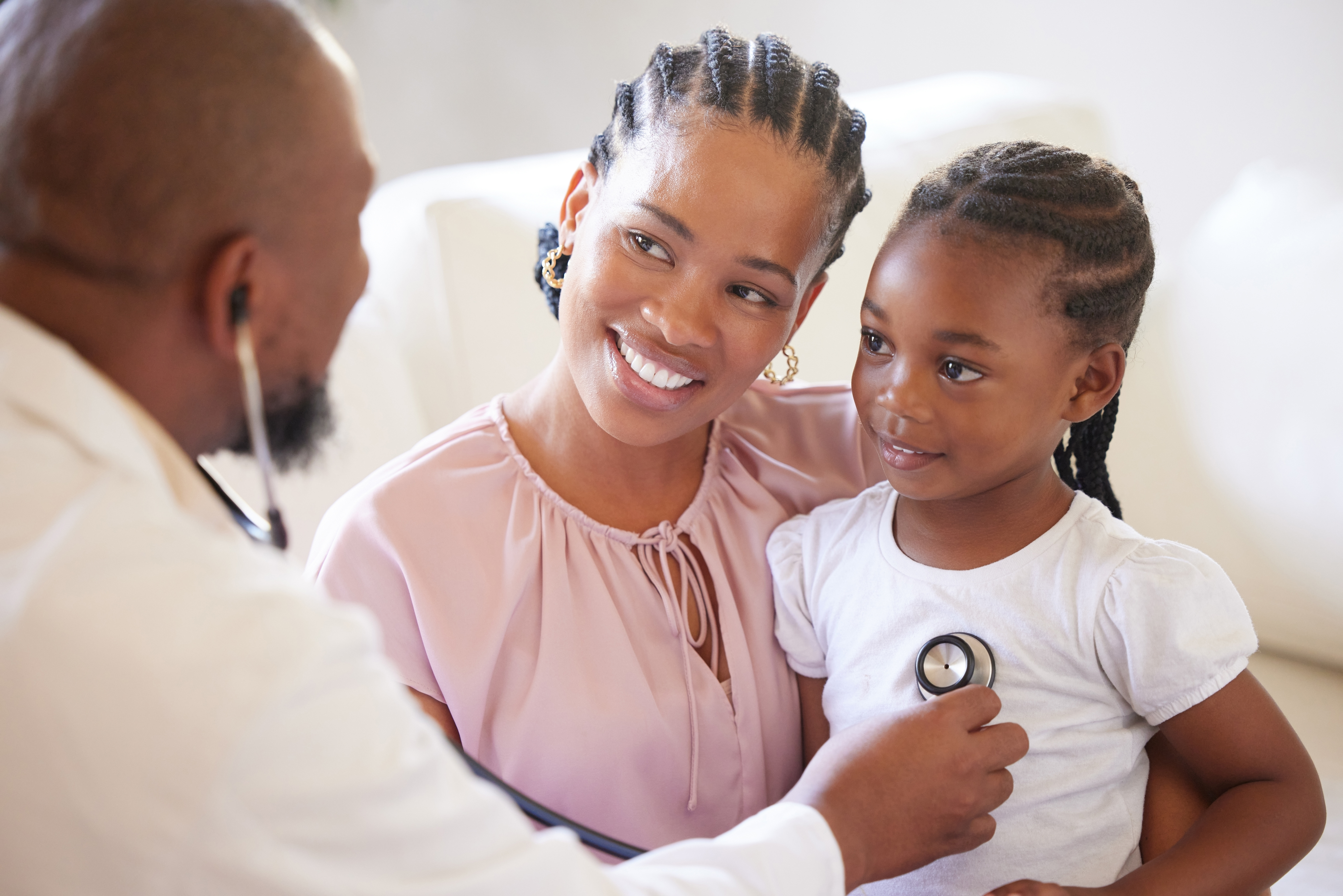Black people, mother and girl with doctor stethoscope for healthcare consultation and healthy lungs in hospital. African mama, young child and male pediatrician with check breathing for wellness for an article on when to seek medical help for your child.