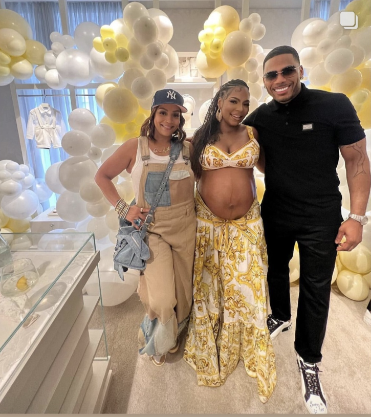 Nelly threw ashanti a surprise baby shower and that celebrates their black love for us as they stand together in a room full of white and yellow balloons.
