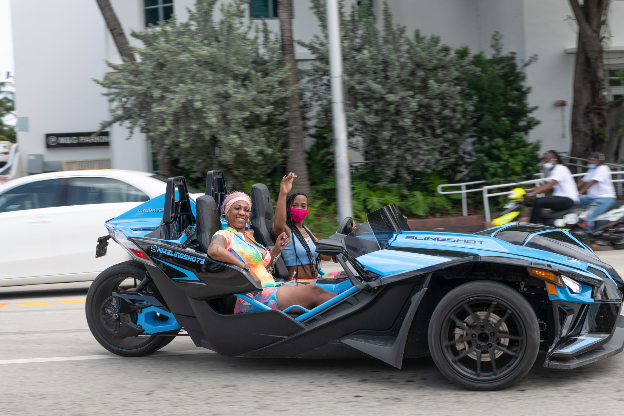 An african american mom rides in a slingshot car for unforgettable ways to pamper mom on her birthday.