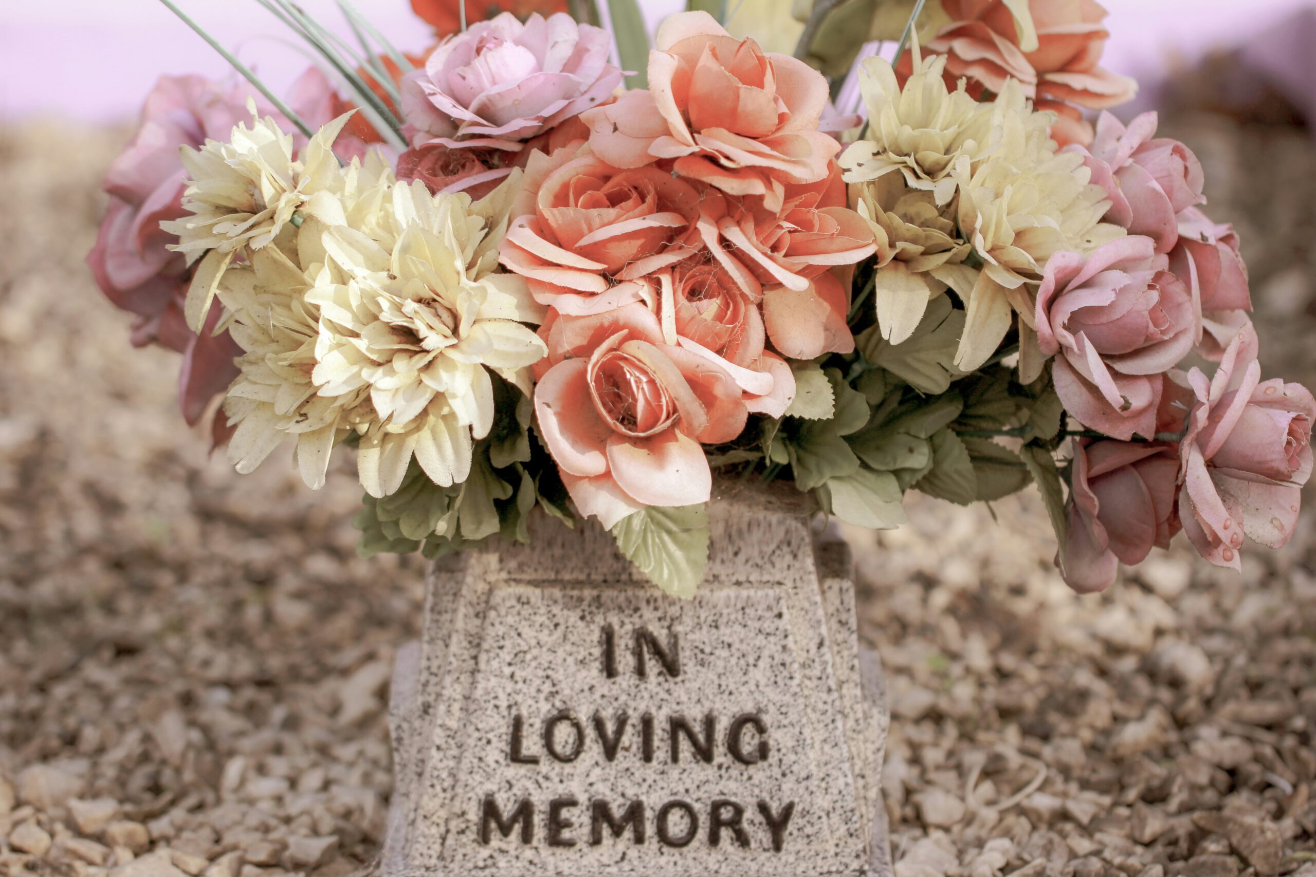 Pink and white flowers on gray concrete tomb for an article on wrongful death