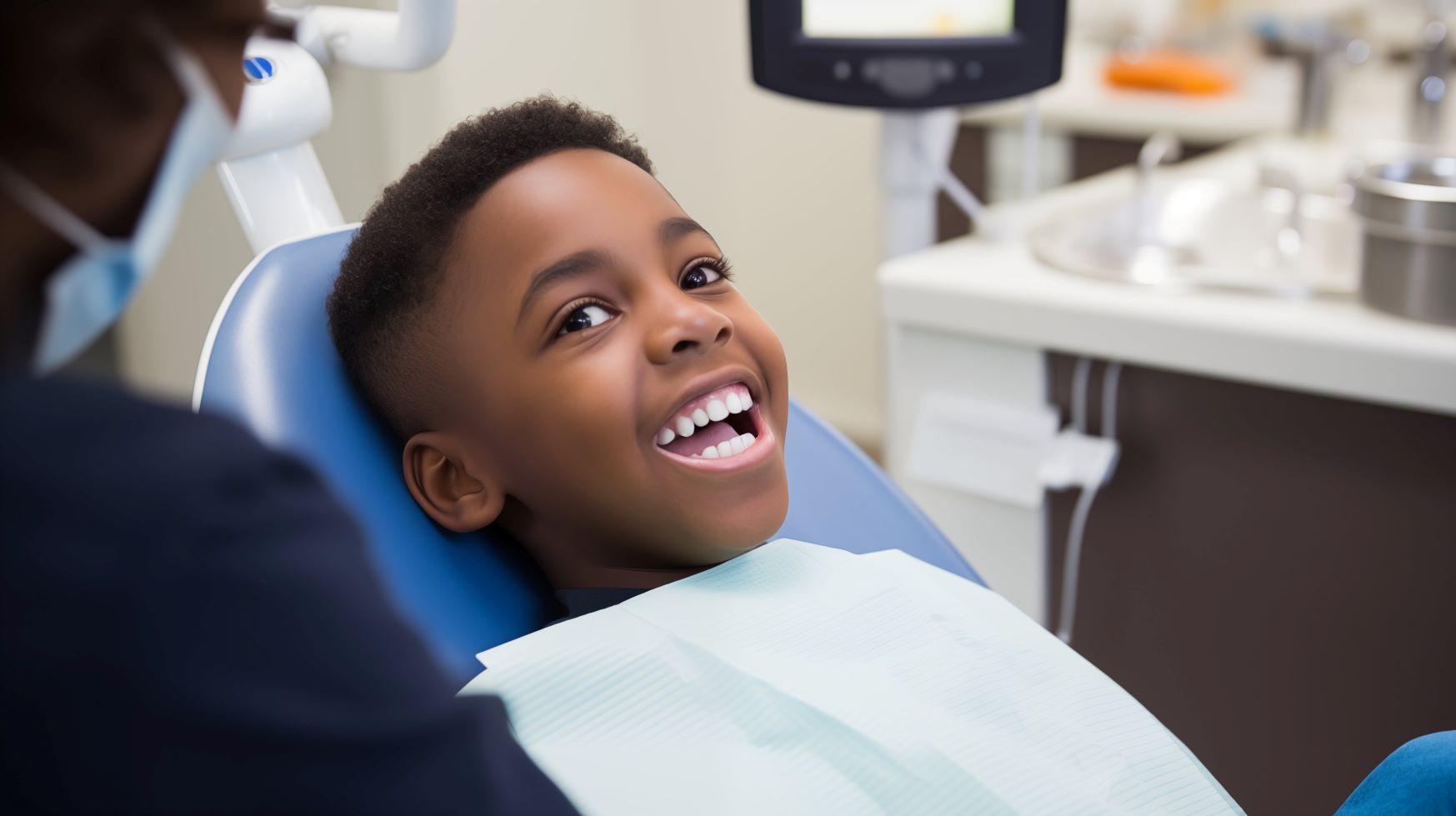 A young african american boy is in the dentist chair to prevent cavities.