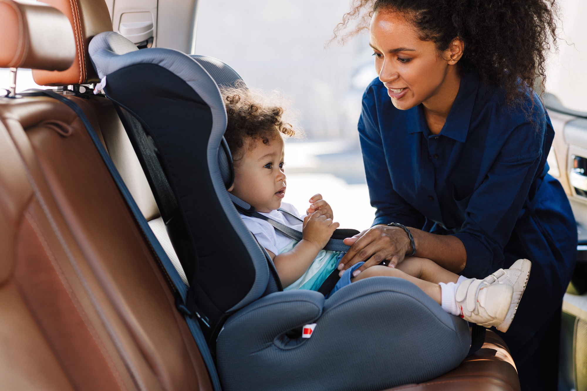 Safety meets simplicity: why 360 rotating car seats are a game-changer for families on the go An african american mom helping her baby in one of those 360 degree car seats.