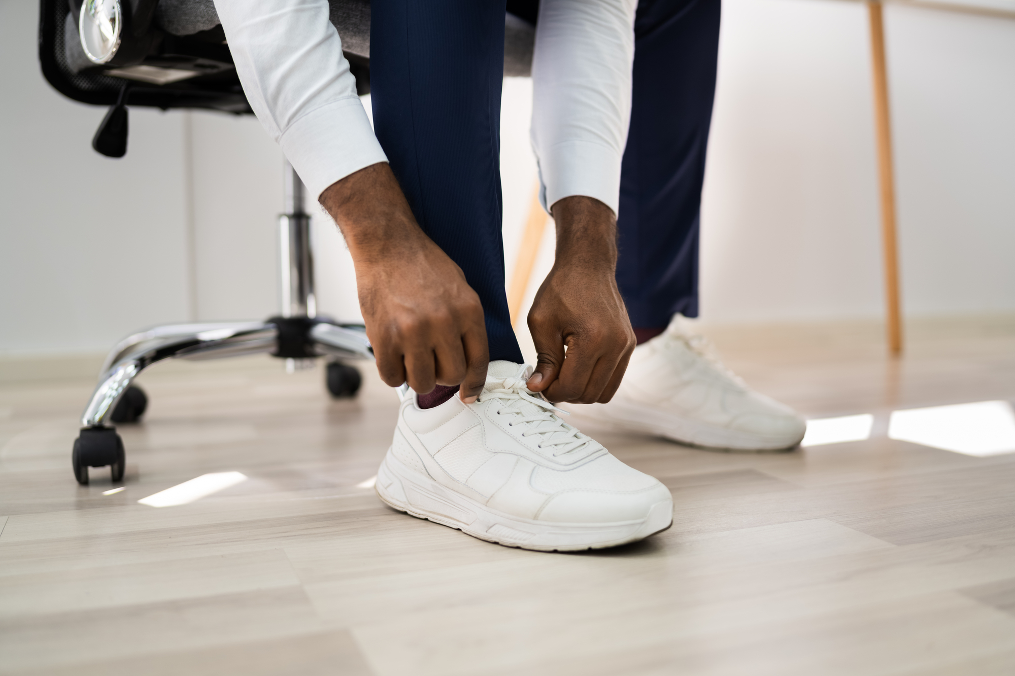 African american man changing to running sports shoes for an article titled, "best wide shoes for senior men: key features to look for and a trusted option. "