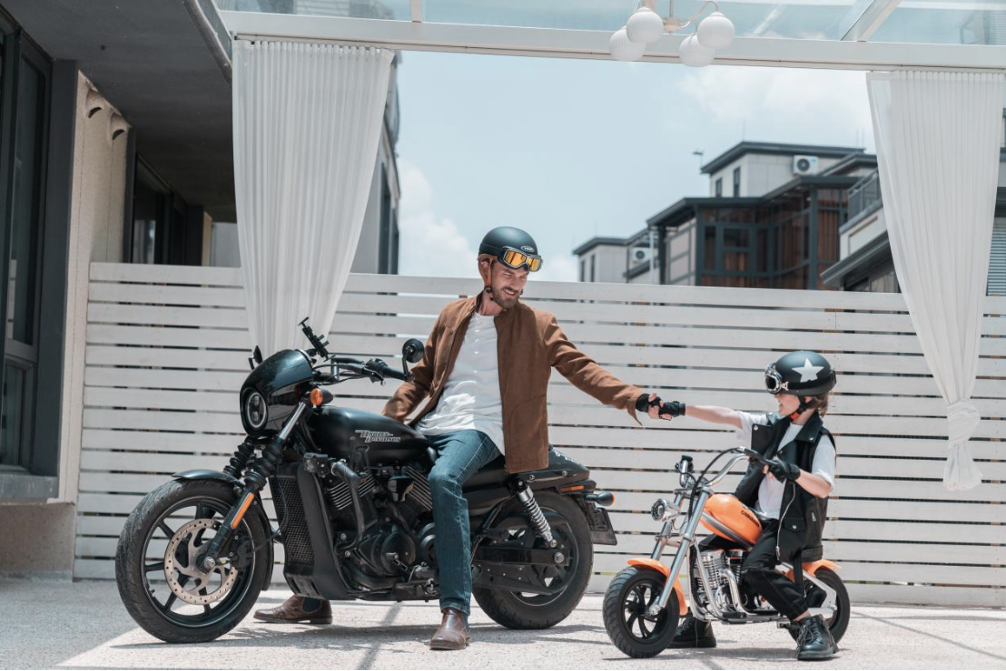 African american father and son enjoying family riding on hyper gogo mini motorcycle, mini motorcycle for kids promoting family riding and bonding, black family outdoor adventure with hyper gogo kids electric motorcycle, father teaching child to ride a mini motorcycle for kids safely, joyful family riding moment with hyper gogo kids electric bike, confident young rider on mini motorcycle for kids during family outdoor fun
