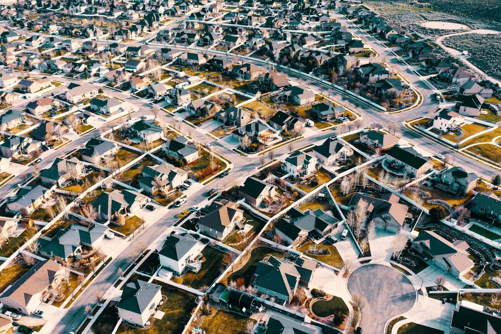 Overhead 3d aerial neighborhood view of a large residential neighborhood with winding roads, cul-de-sacs, and neatly arranged houses.