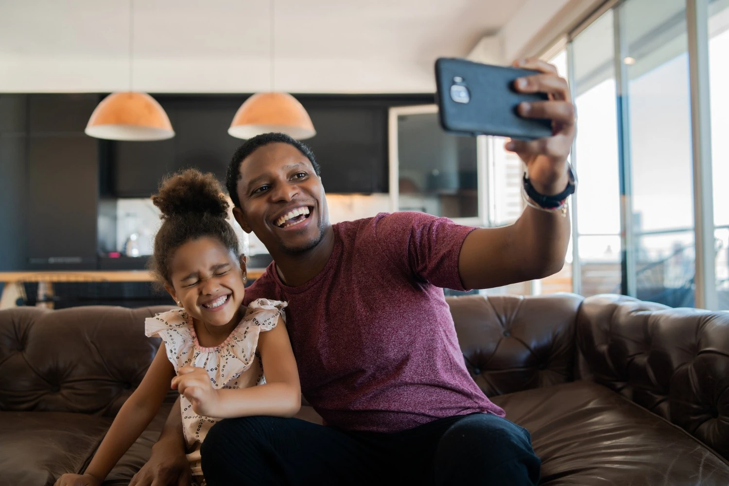 Creating family video masterpieces father and child taking a joyful selfie video at home