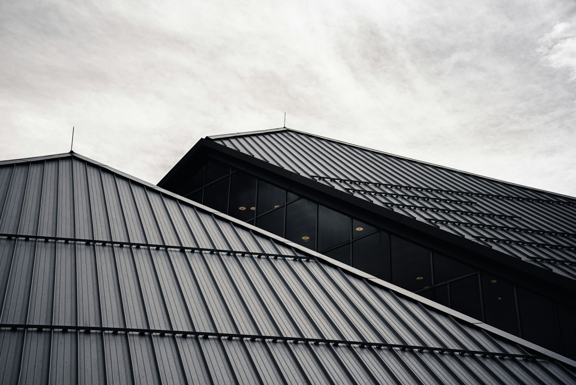 Modern metal roof installation on a contemporary home exterior representing budgeting and planning for major home renovation projects.