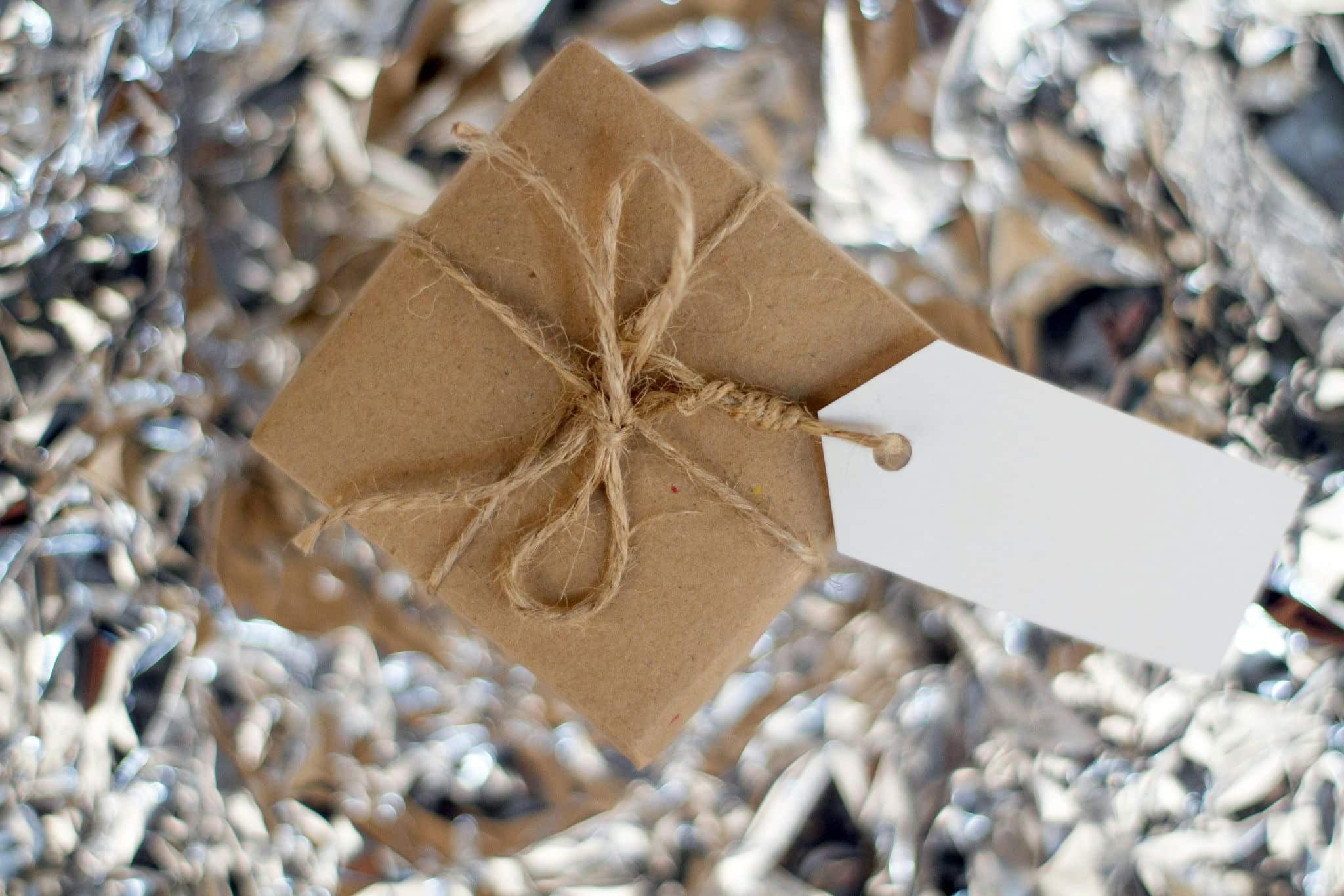 Personalized gift wrapped in brown paper with twine and a blank white tag, featured in a customjoy. Com review.