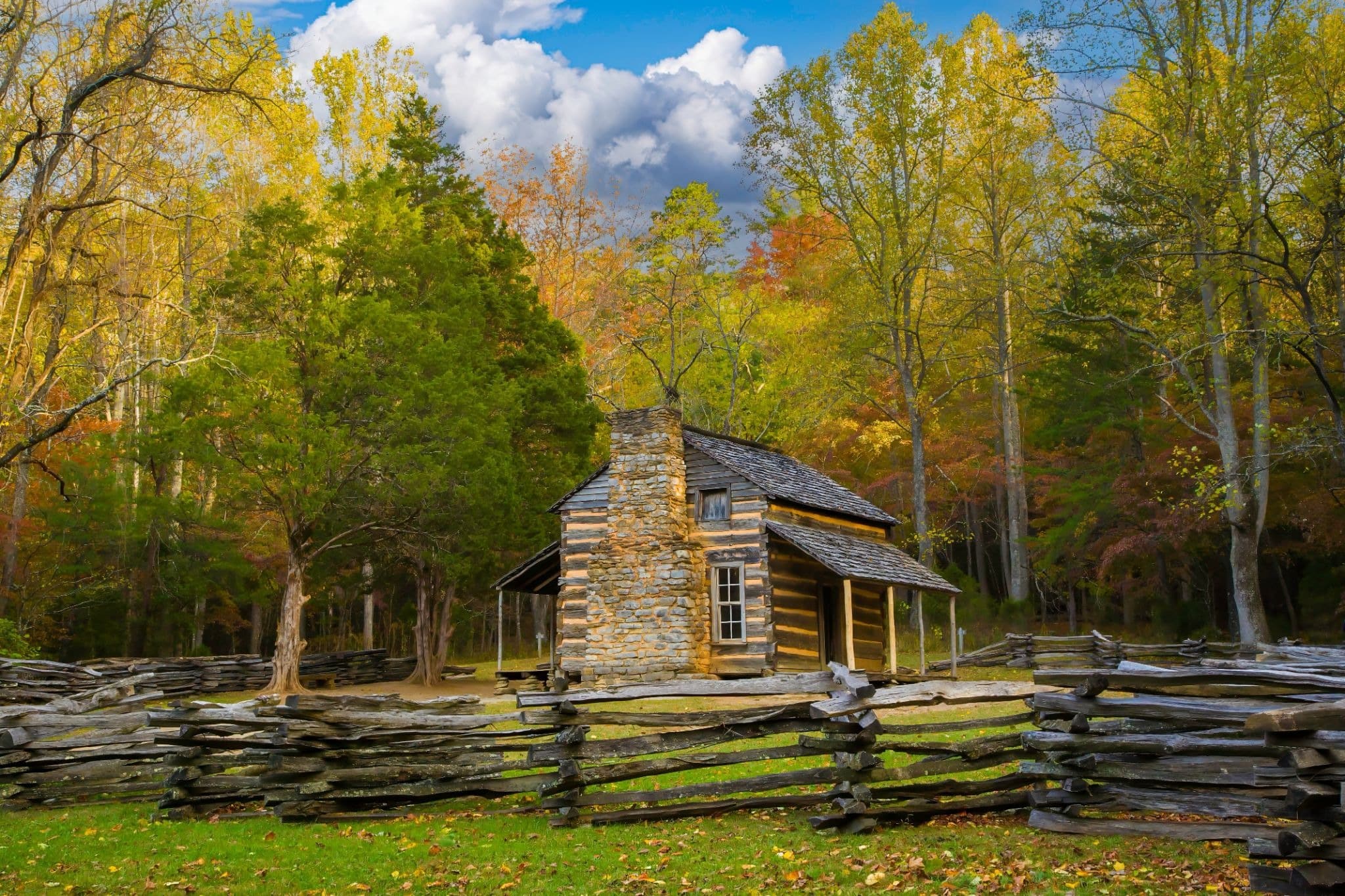 Historic ogle cabin surrounded by autumn foliage during a family vacation traveling to the smokies near gatlinburg, tennessee
