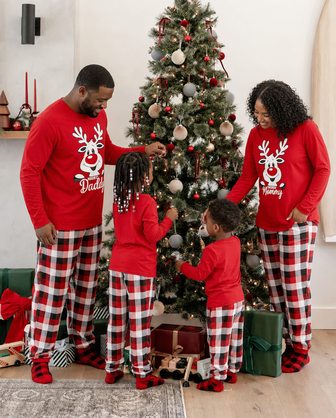 African american family building blended family christmas traditions while decorating the tree in matching christmas pajamas