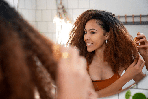 Black mom applying at-home hair color for dark hair during a confidence-boosting self-care routine for a mom's weekend.